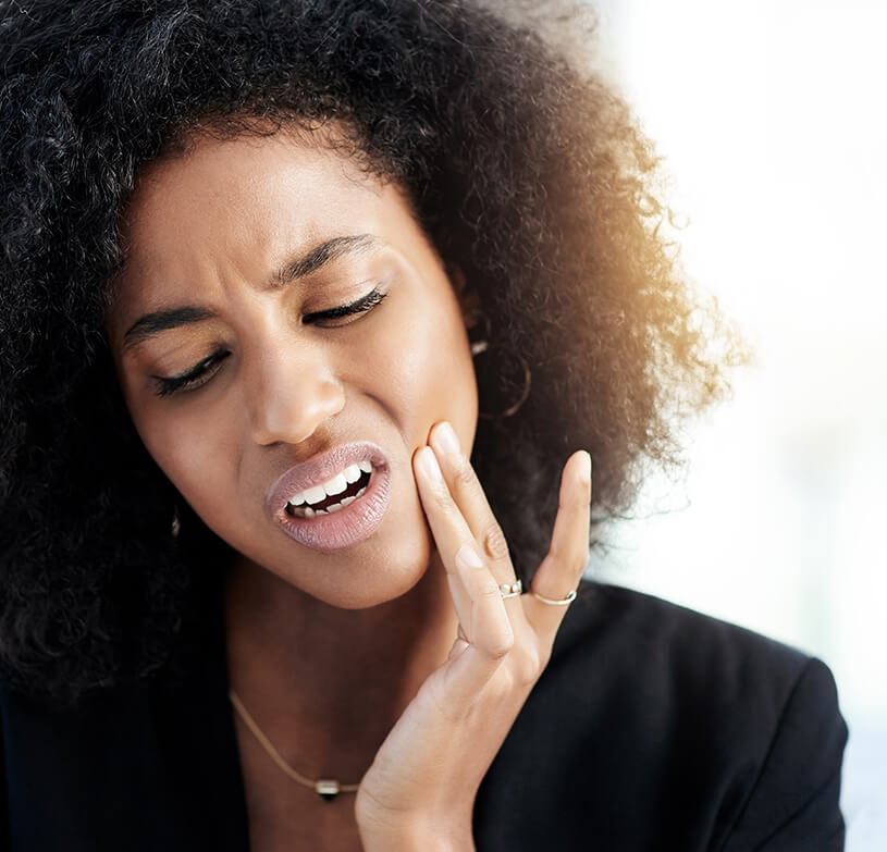 woman holding her jaw in pain