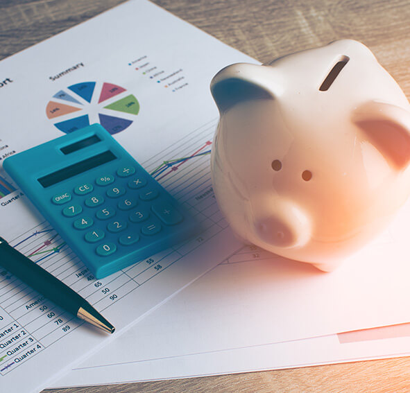 piggy bank sitting next to a calculator and an ink pen