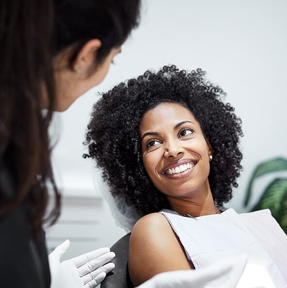 smiling woman talking with her dentist