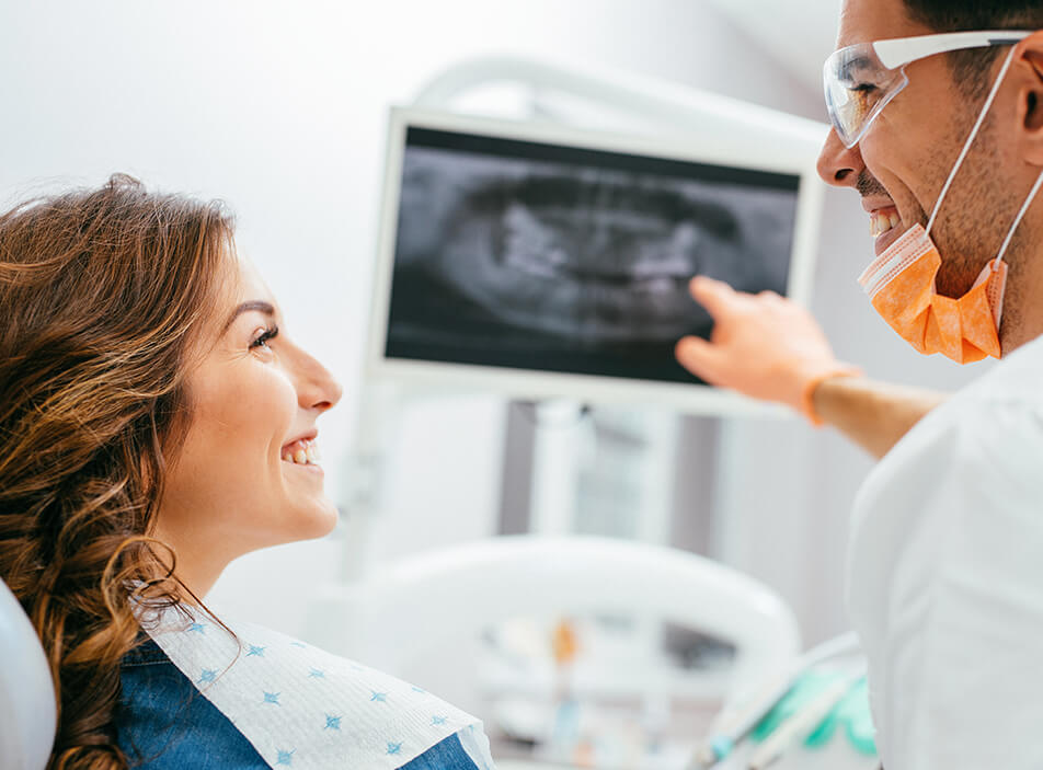 dentist explaining a woman's x-rays to her