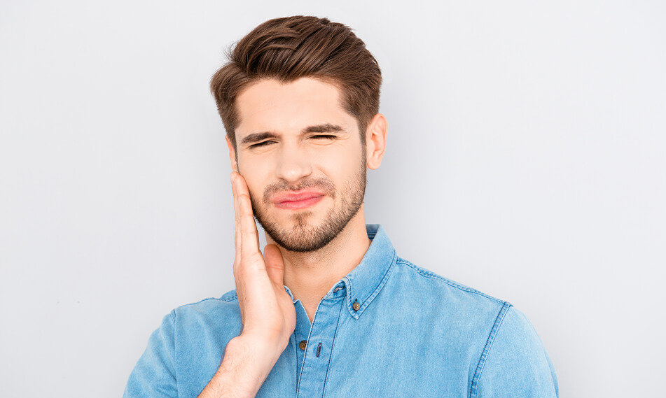 man holding his jaw in pain