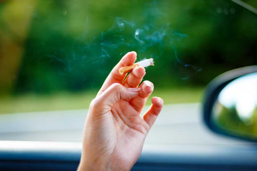 person's hand holding a cigarette