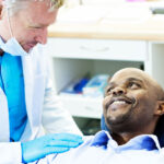 dentist consults with a man in the dentist chair about dental implants