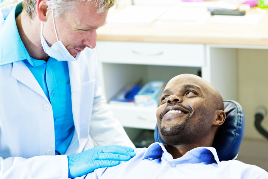 dentist consults with a man in the dentist chair about dental implants