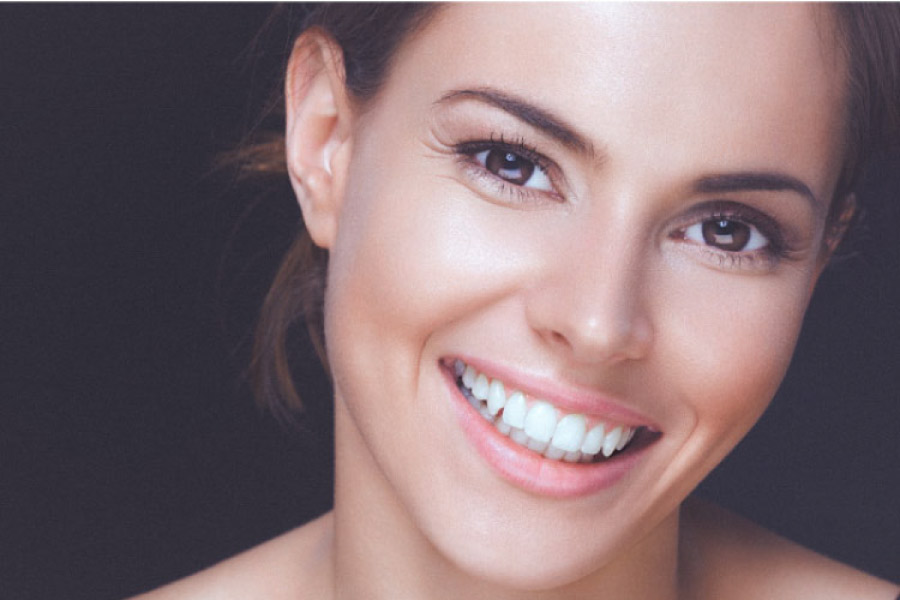 woman smiles showing off her porcelain veneers