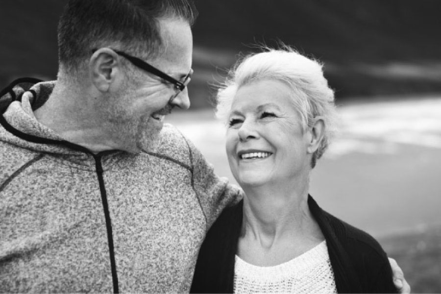 senior couple walk close together and smile after learning about diabetes and oral health