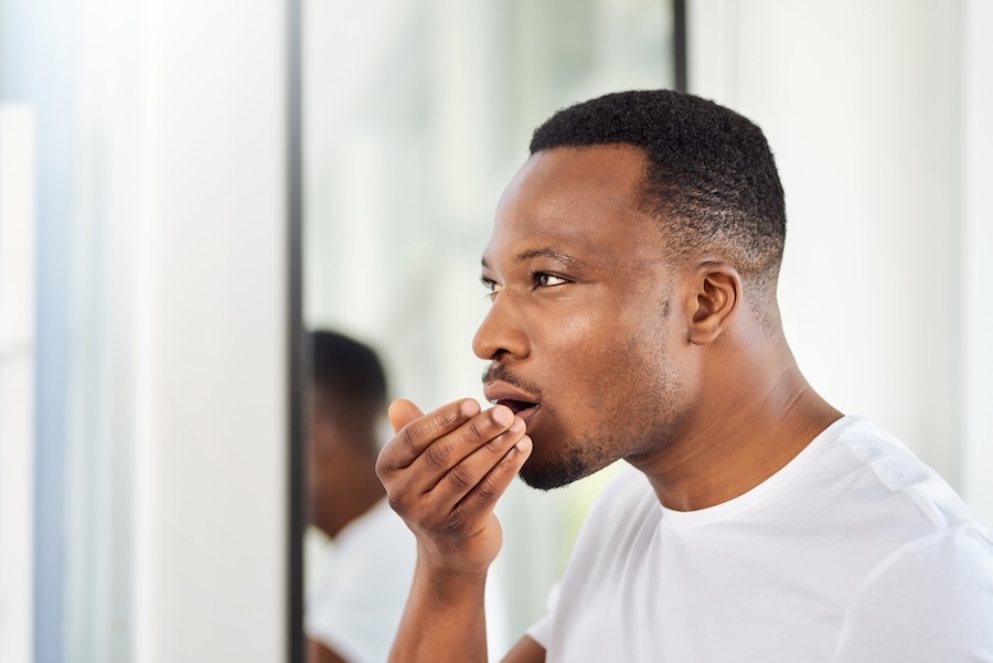 man checking for bad breath or halitosis