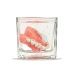 denture care, dentures soaking in cup